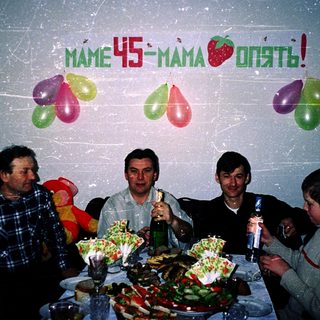 Family celebrating 45th birthday with balloons and drinks.