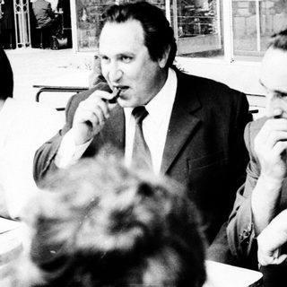 Businessmen gathered indoors during a formal meeting.