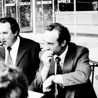 Businessmen gathered indoors during a formal meeting.
