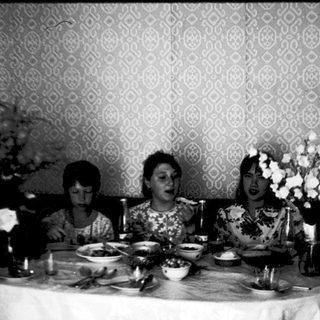 Three women seated at a formal dinner table.