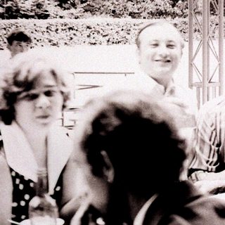 Group of people socializing outdoors at a table.