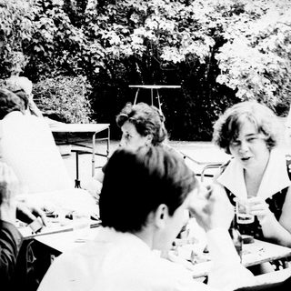 Group gathered outdoors at a table, engaged in conversation.