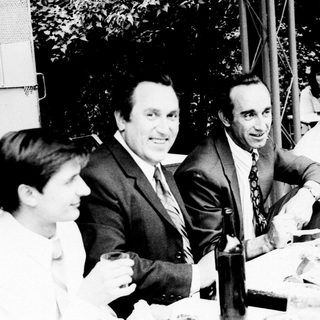 Business meeting or informal gathering of men outdoors.