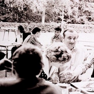 Group of people gathered outdoors at a table.