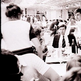 Business lunch gathering in outdoor dining area.