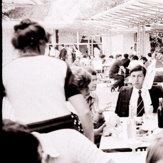 Business lunch gathering in outdoor dining area.