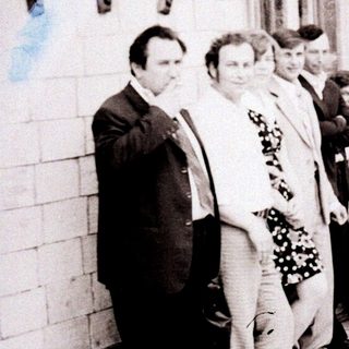 Group of people posing outside a building in the 1970s–1980s.