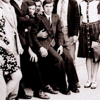 Group of people posing outside an industrial building.