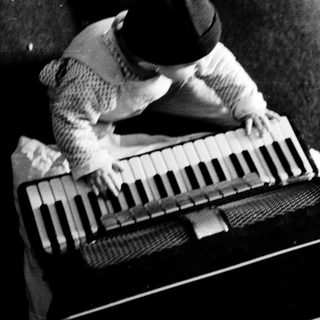 Person playing vintage accordion on couch.