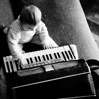 Young child playing accordion indoors.