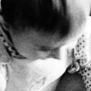 Young child playing accordion indoors.