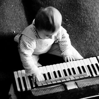 Young child playing accordion indoors.
