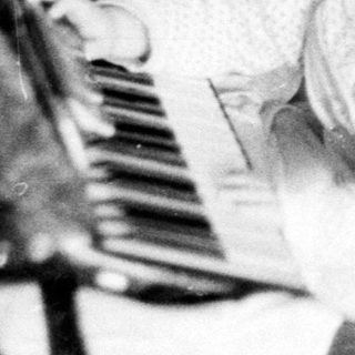 Baby playing with toy piano indoors.