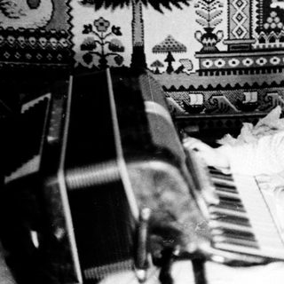 Baby sitting on piano in decorated nursery.