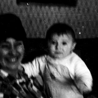 Two infants in a dimly lit indoor setting.