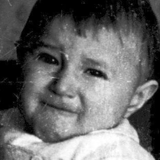 A child crying while being held indoors.