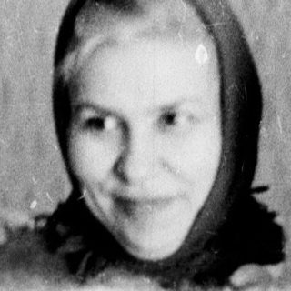 A woman and baby indoors, smiling.