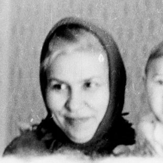 A woman and baby indoors, smiling.
