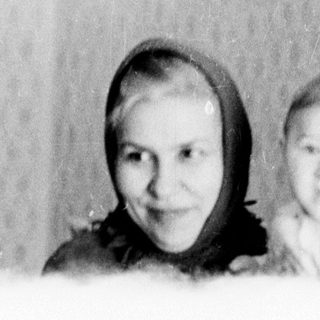 A woman and baby indoors, smiling.