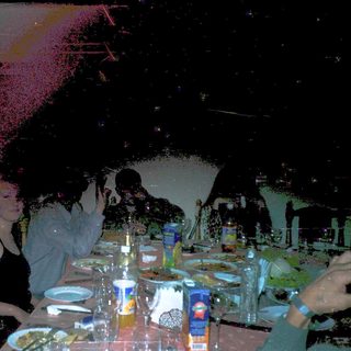 People dining indoors with dim lighting and confetti.