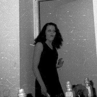 Woman standing in doorway holding small object.