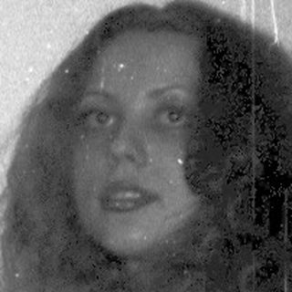 Woman in leopard print dress using vintage camera indoors.