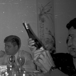 People toasting with drinks at a social gathering.