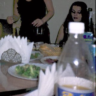 Three women at a dimly lit dinner table.