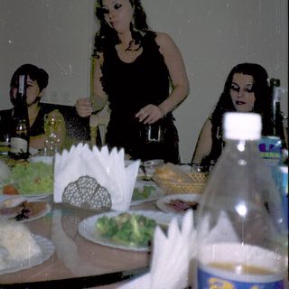 Three women at a dimly lit dinner table.