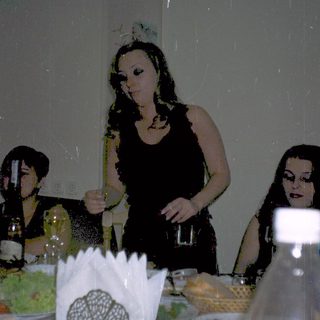 Three women at a dimly lit dinner table.
