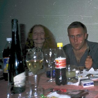 Three people enjoying drinks at a casual indoor gathering.