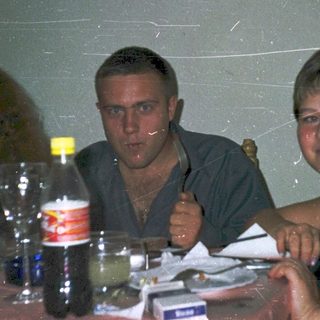 Three people enjoying drinks at a casual indoor gathering.