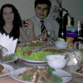 Three people dining together at a table with food and drinks.
