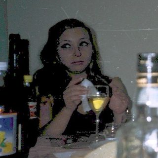 Three people dining together at a table with food and drinks.