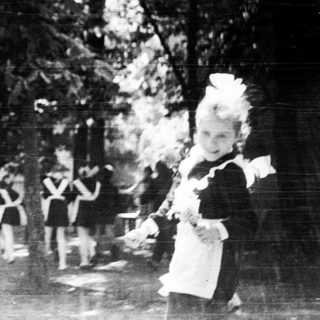 Young girls in school uniforms playing outdoors.