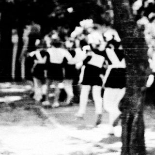 Group of schoolgirls walking outdoors at dusk.