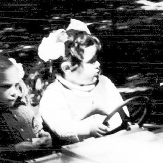 Two children riding a dark indoor log flume ride.