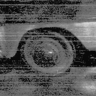 A person driving a vintage car at night.