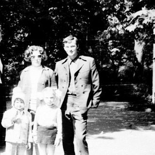 Family portrait outdoors in wooded area.