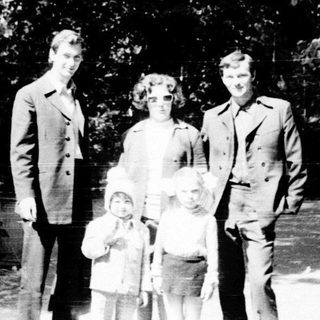 Family portrait outdoors in wooded area.