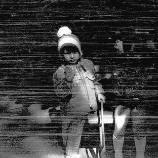 Child skiing against dark wooden background.