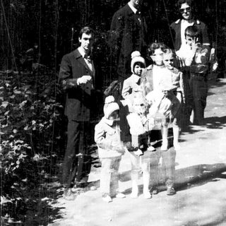 Family group hiking in forested area.