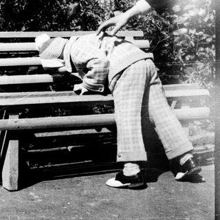 Two children playing on a bench outdoors.
