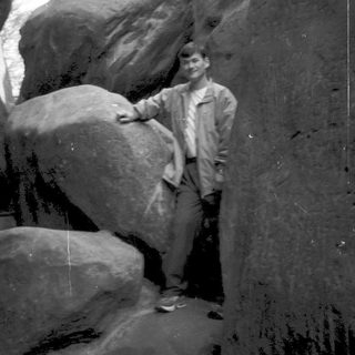 Person standing between large rock formations.
