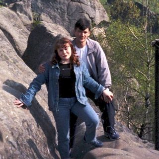 Two people hiking on rocky mountain summit.