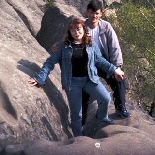 Two people hiking on rocky mountain summit.