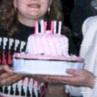 Family celebrating birthday indoors with cake.