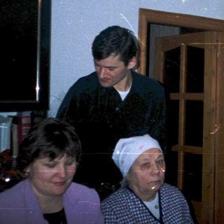 Family celebrating birthday indoors with cake.