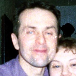 A man and child hugging indoors.
