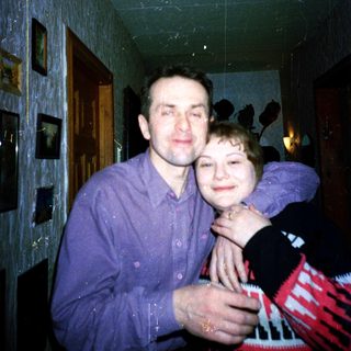 A man and child hugging indoors.